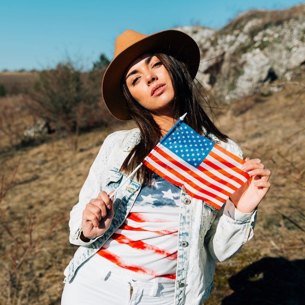 Beautiful female holding American flag in nature