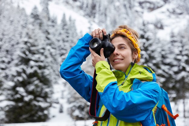 Beautiful female makes photo on professional camera