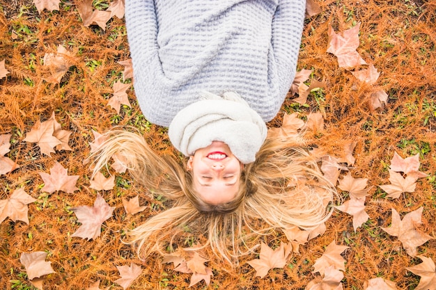 Free photo beautiful female model laying on autumn grass