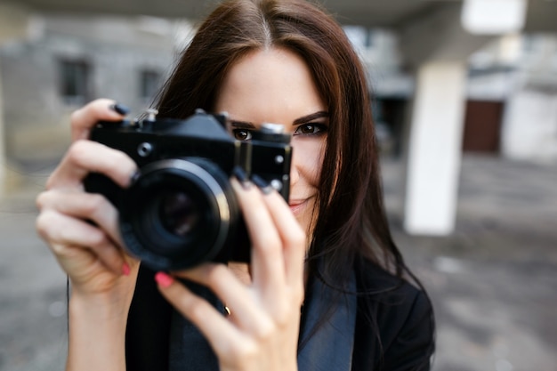 Beautiful female photographer posing with camera