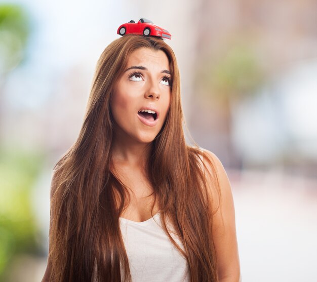 Beautiful female with a car model on her head