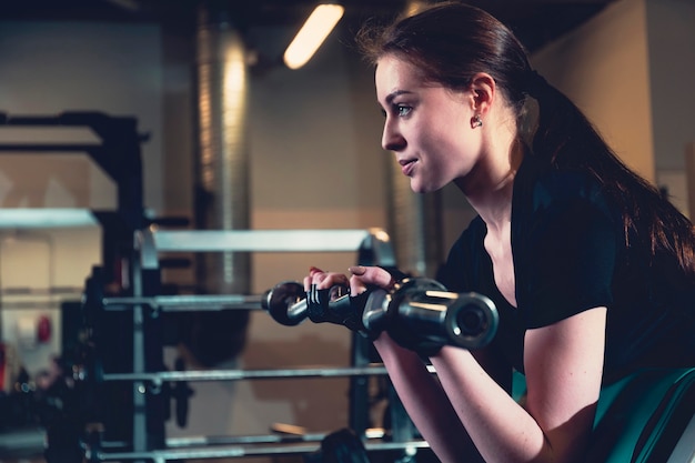 Beautiful fit woman doing exercise in fitness center