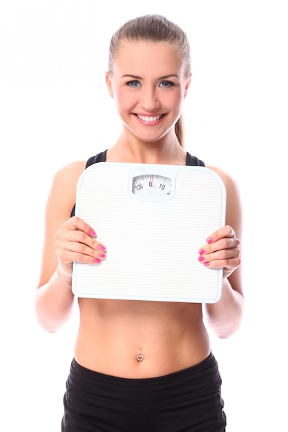 Free photo beautiful fitness girl holding scales