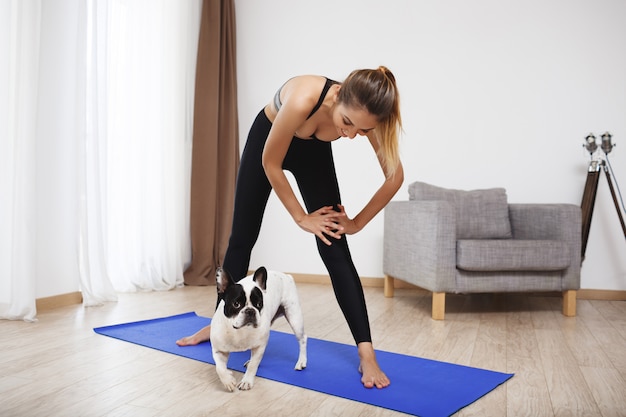 Beautiful fitness girl  make sport exercises with dog