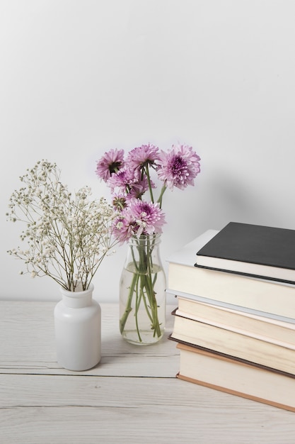 Free photo beautiful flowers next to book pile