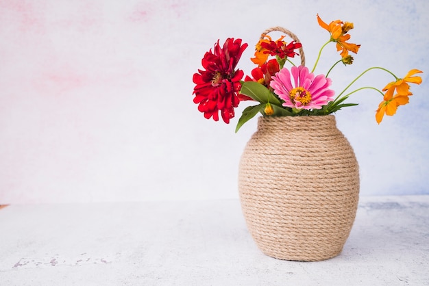 Free photo beautiful flowers in the vase on grunge backdrop