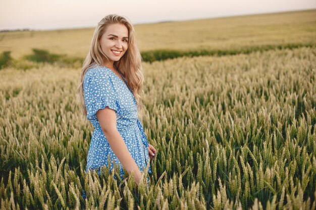 Beautiful girl in a blue dress. Woman in a summer field.