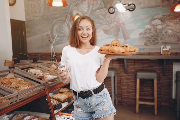 Free photo beautiful girl buys buns at the bakery