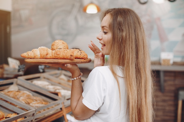 Beautiful girl buys buns at the bakery