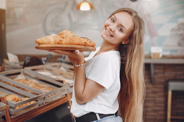 Free photo beautiful girl buys buns at the bakery