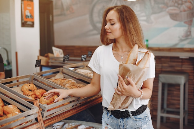 Free photo beautiful girl buys buns at the bakery