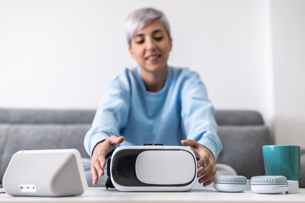 Beautiful girl on the couch in her living room picking up a Virtual reality glasses