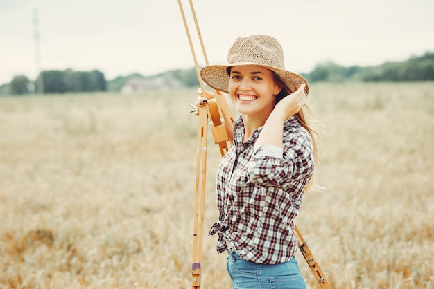 Beautiful girl drawing in a field