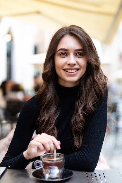 Free photo beautiful girl having coffee at outdoors cafe