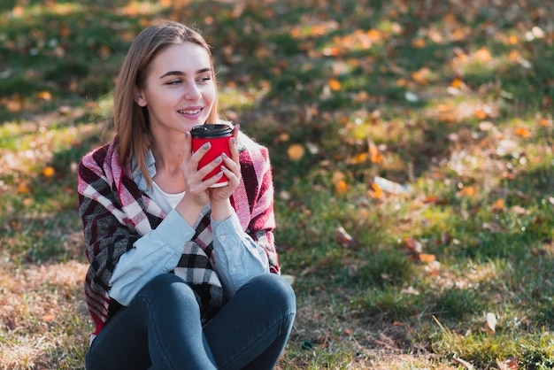 Beautiful girl holding a coffee cup and looking away