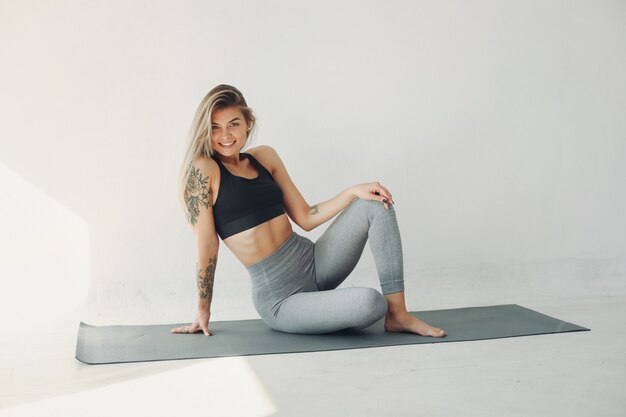 A beautiful girl is engaged in a yoga studio