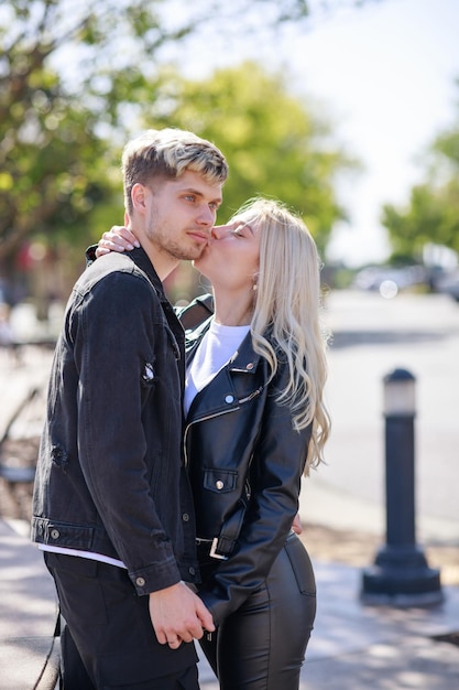 A beautiful girl kissing her boyfriend at the park