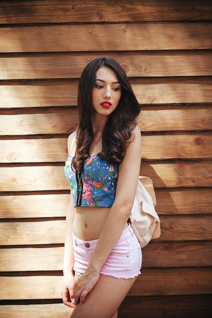 Beautiful girl posing on brown wall