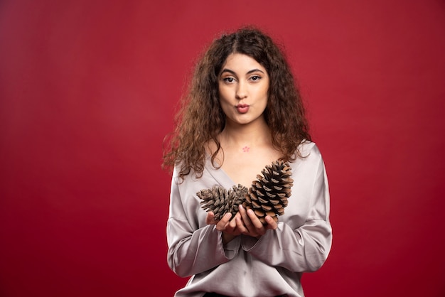 Beautiful girl posing with pinecones and looking.