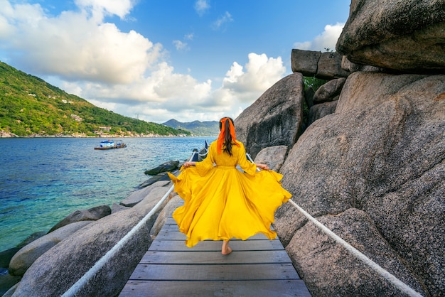 Beautiful girl running on wooden path at Koh Nang yuan island near Koh Tao island, Surat Thani in Thailand