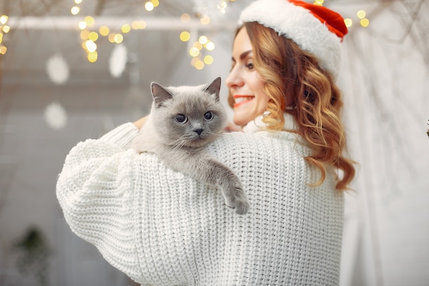 Beautiful girl sitting on a bed with cute kitty