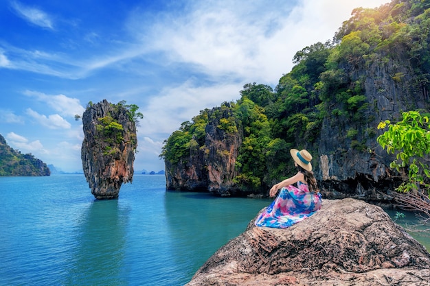 Free photo beautiful girl sitting on the rock at james bond island in phang nga, thailand.