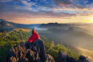 Free photo beautiful girl sitting on sunrise viewpoint at ja bo village, mae hong son province, thailand