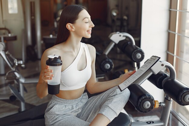 A beautiful girl sitting with water in a gym