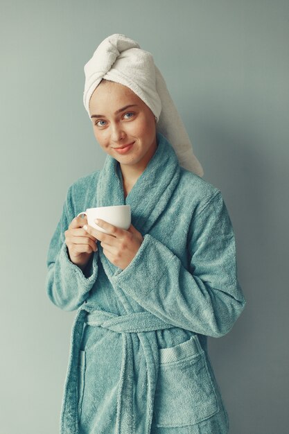 Beautiful girl standing  in a blue bathrobe