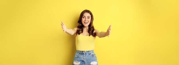 Free photo beautiful girl in tank top reaching hands stretching arms forward and smiling welcome hugging or gre