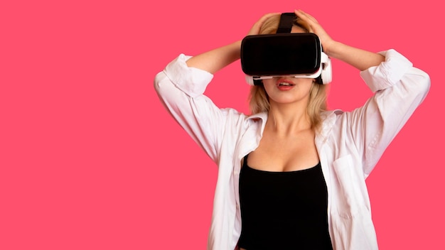 Free Photo beautiful girl in vr glasses on a pink background in virtual reality