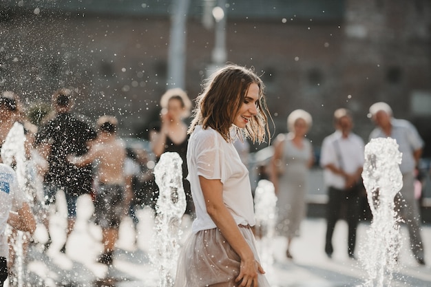 The beautiful girl walking near fountain