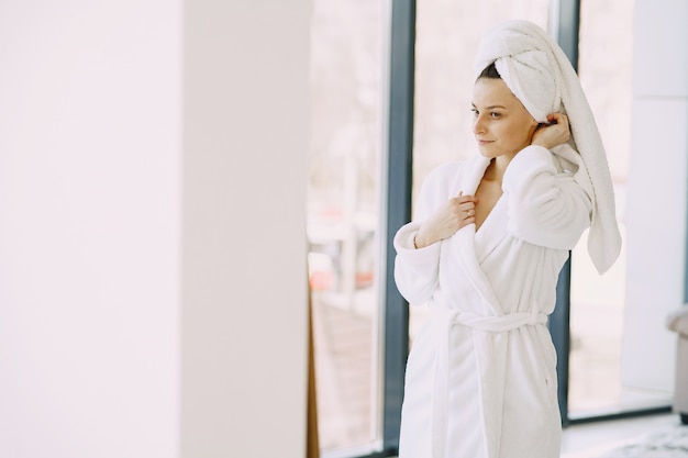 Free photo beautiful girl in a white bathrobe at home