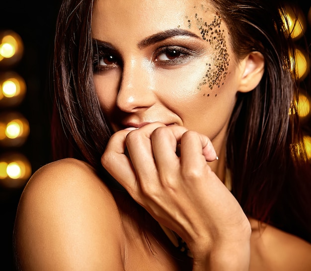 beautiful girl with golden glitter on the face