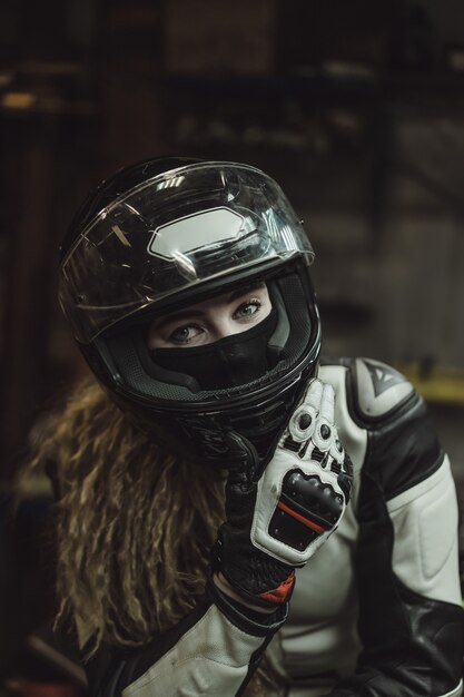 beautiful girl with long hair in the garage repairing a motorcycle