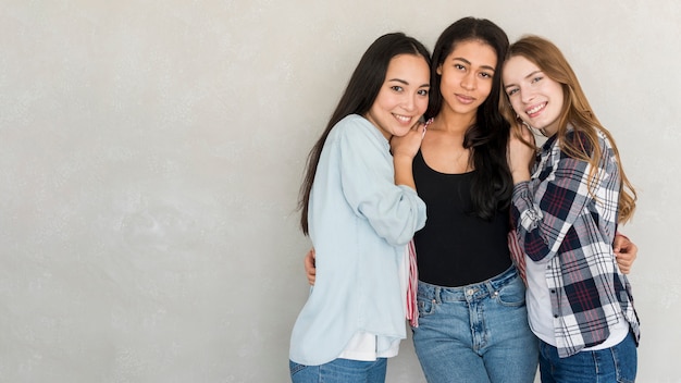 Beautiful girlfriends hugging in studio