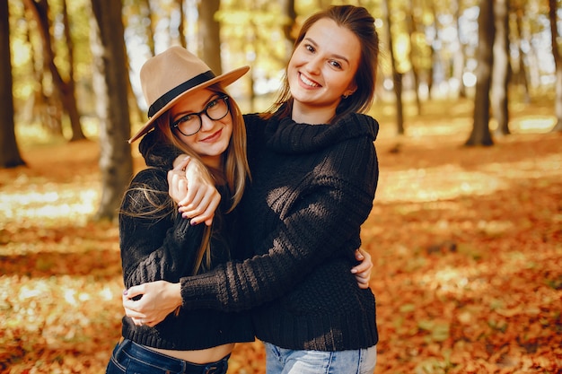 Beautiful girls have fun in a autumn park