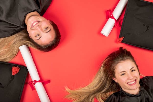 Free Photo beautiful graduates with red background