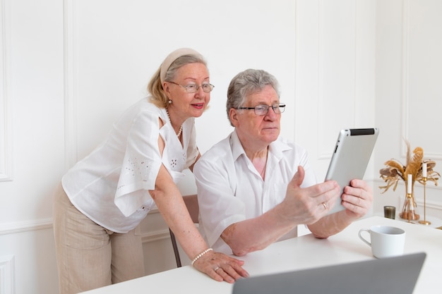 Beautiful grandparents couple learning to use digital device