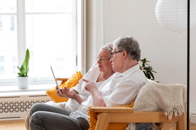 Beautiful grandparents couple learning to use digital device