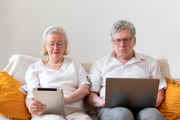 Beautiful grandparents couple learning to use digital device