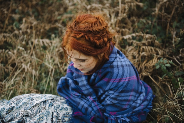 Free photo beautiful high angle shot of a ginger female with a pure white skin in a blue covering