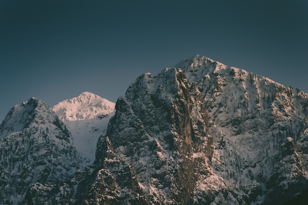 Free photo beautiful high rocky mountains with a snowy mountain in between