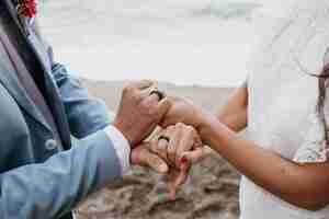 Free photo beautiful husband and wife posing on the beach at their wedding