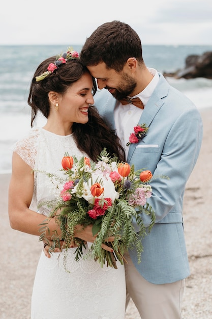 Beautiful husband and wife posing on the beach