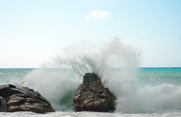 Beautiful image of strong waves crashing on the rocks on a shore