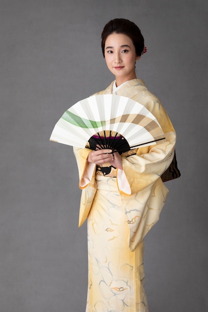 Free photo beautiful japanese woman with a minimalist hand fan