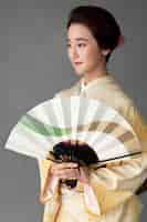 Free photo beautiful japanese woman with a minimalist hand fan