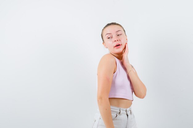 Beautiful lady is turning to her right side and looking at her left side on white background