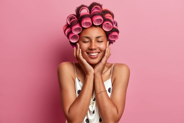 Beautiful lady wearing hair curlers isolated